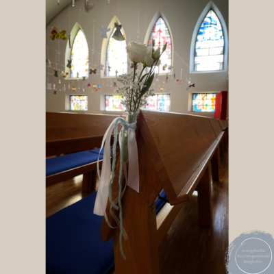 Das Bild zeigt festlichen Blumenschmuck an einer Kirchenbank in der Kreuzkirche.